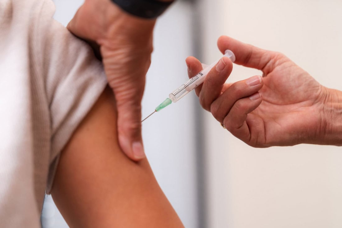 A person receives an injection in the arm for vaccination.