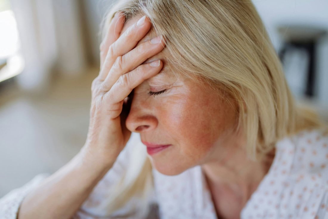 Headaches and dizziness in older woman, health problems, health care.