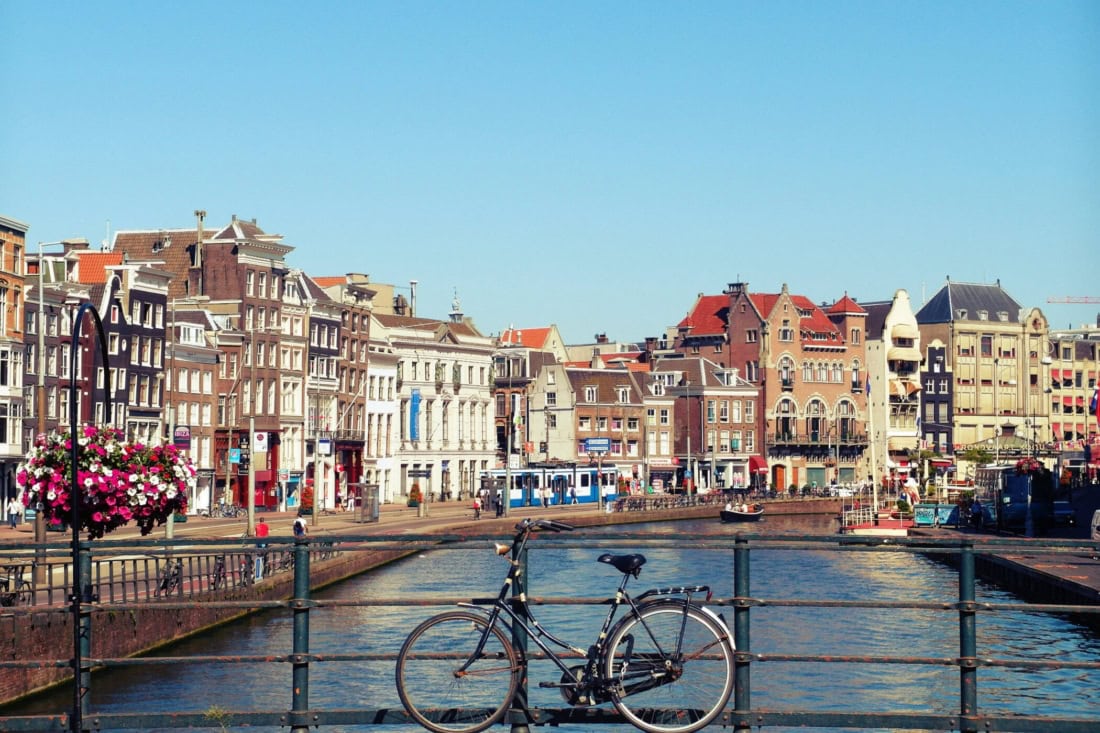 Cyclist by canal with historic buildings in the Netherlands, information for foreigners.