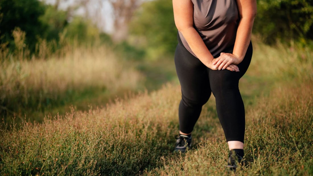 Overweight and body weight, woman in sportswear in nature setting.